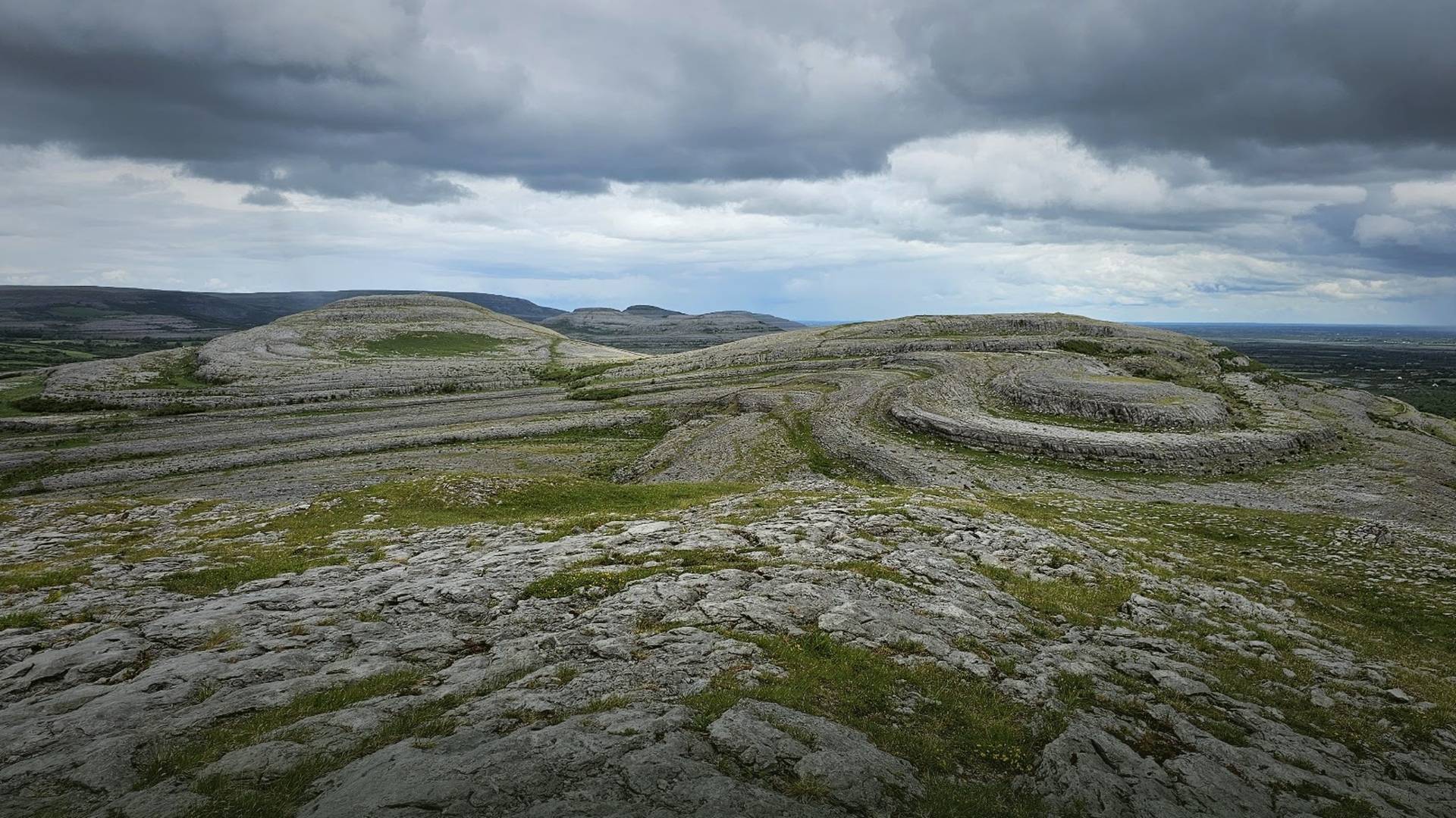 The Burren limestone terraces under storm cloud, County Clare